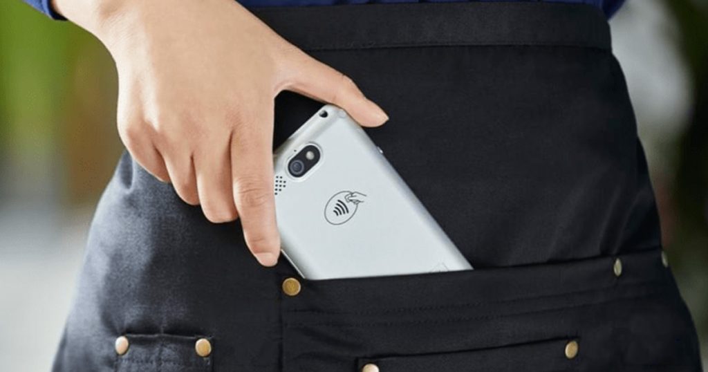 a portable card machine being carried in an apron pocket