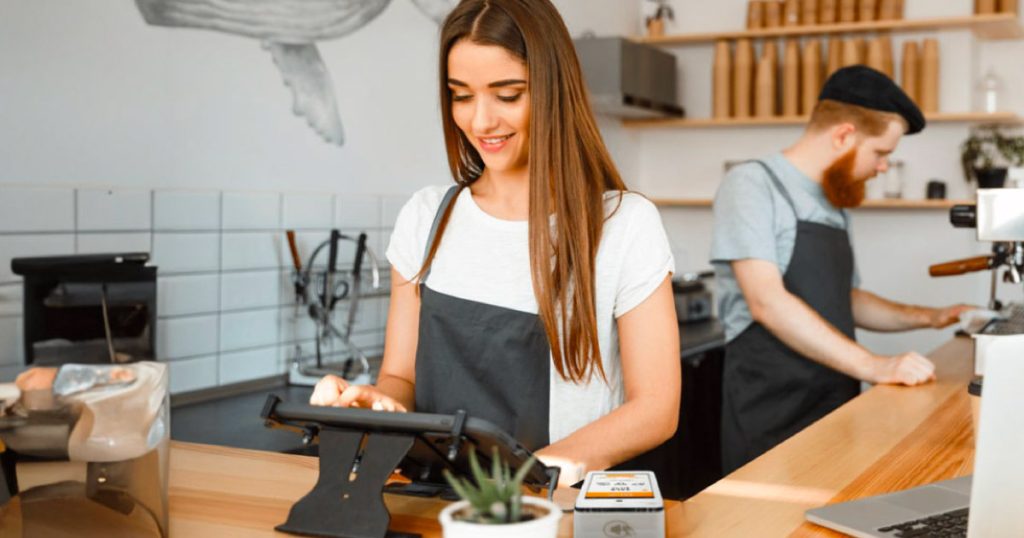 a woman experiences the benefits of EPOS for hospitality in a cafe