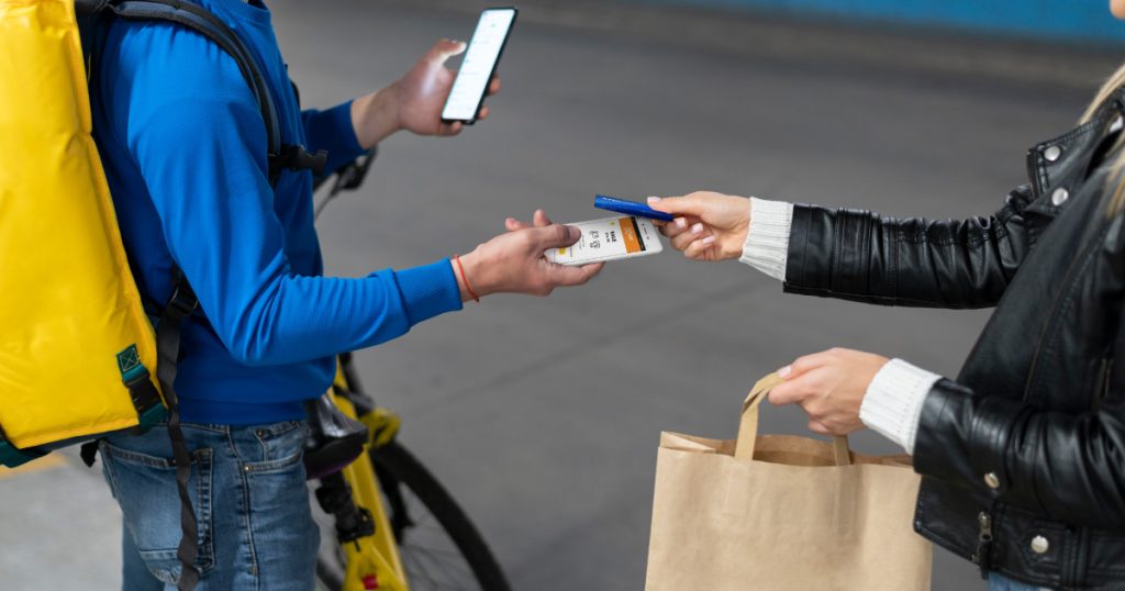 a customer pays a delivery person with a mobile card reader