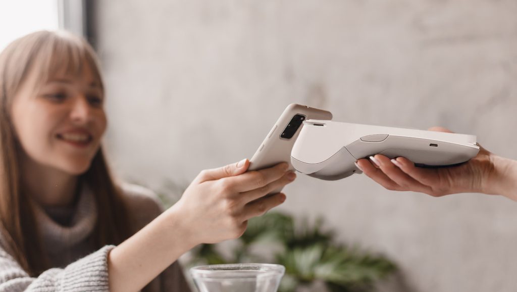 Irish business customer making contactless payment using multi-currency payment processing Ireland technology