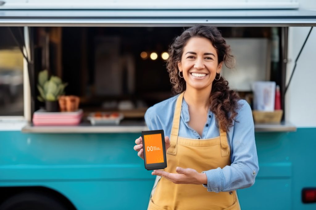 Irish business owner demonstrating card reader for market stalls Ireland outside his vendor booth.