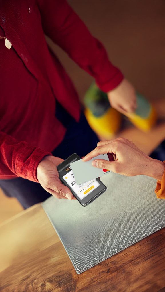 No contract card machines Ireland: seasonal business owner accepting contactless payment with NPI terminal at outdoor market