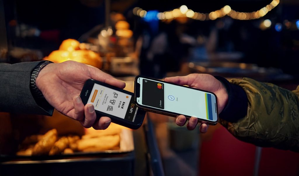 Hand holding Castles S1 MINI 2 mobile payments Ireland card reader with customer making contactless payment on food truck