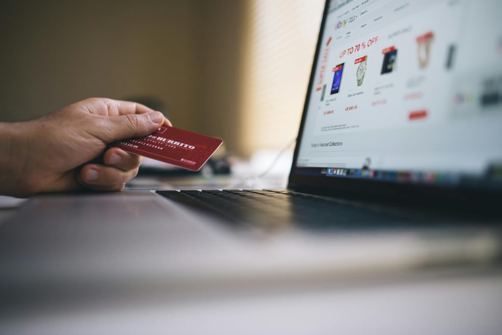 E-commerce payments Ireland hand holding debit card laptop screen online payment solutions Ireland website payment integration