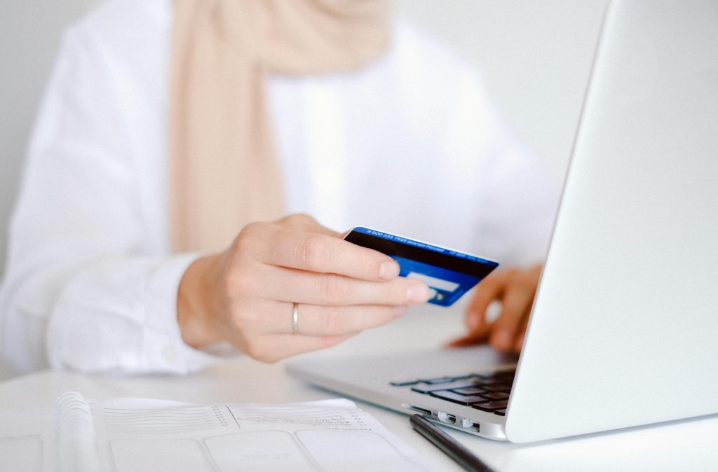 Payment gateway Ireland hand holding credit card typing laptop keyboard online payment gateway Ireland implementation