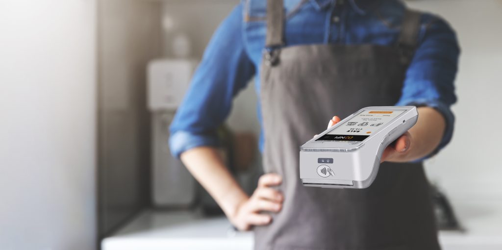 Waiter extending PAX A920 PRO credit card processing Ireland terminal for customer payment in restaurant setting