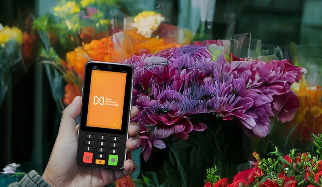 florist holding PAX A35 card machine demonstrating EPOS system cost Ireland affordability and POS system price Ireland for small businesses with budget-friendly solutions
