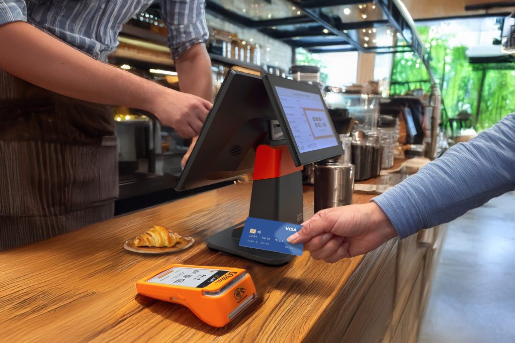 person making contactless payment coffee shop EPOS system PAX A920 PRO demonstrating EPOS card machine integration Ireland and integrated payment solutions Ireland