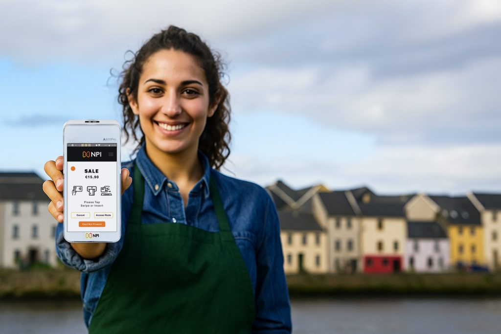 Card machine Galway shown by a female barista holding a payment terminal on Galway streets
