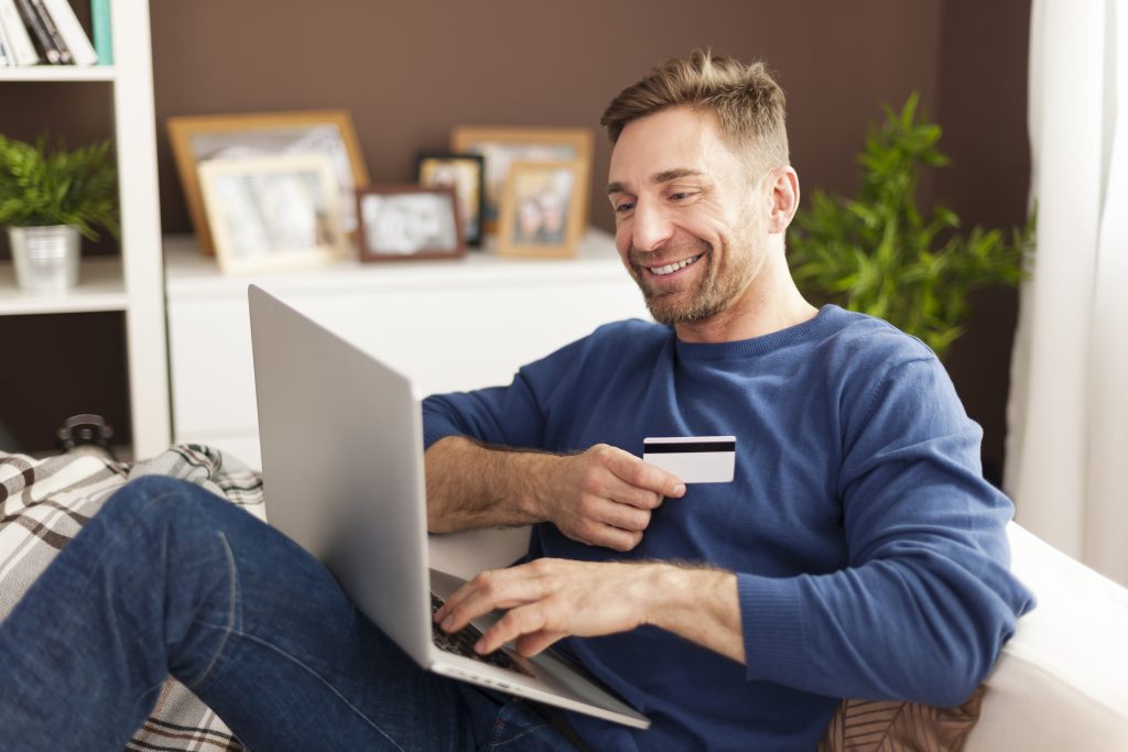 Person making secure online payment on laptop using Irish online payment gateway